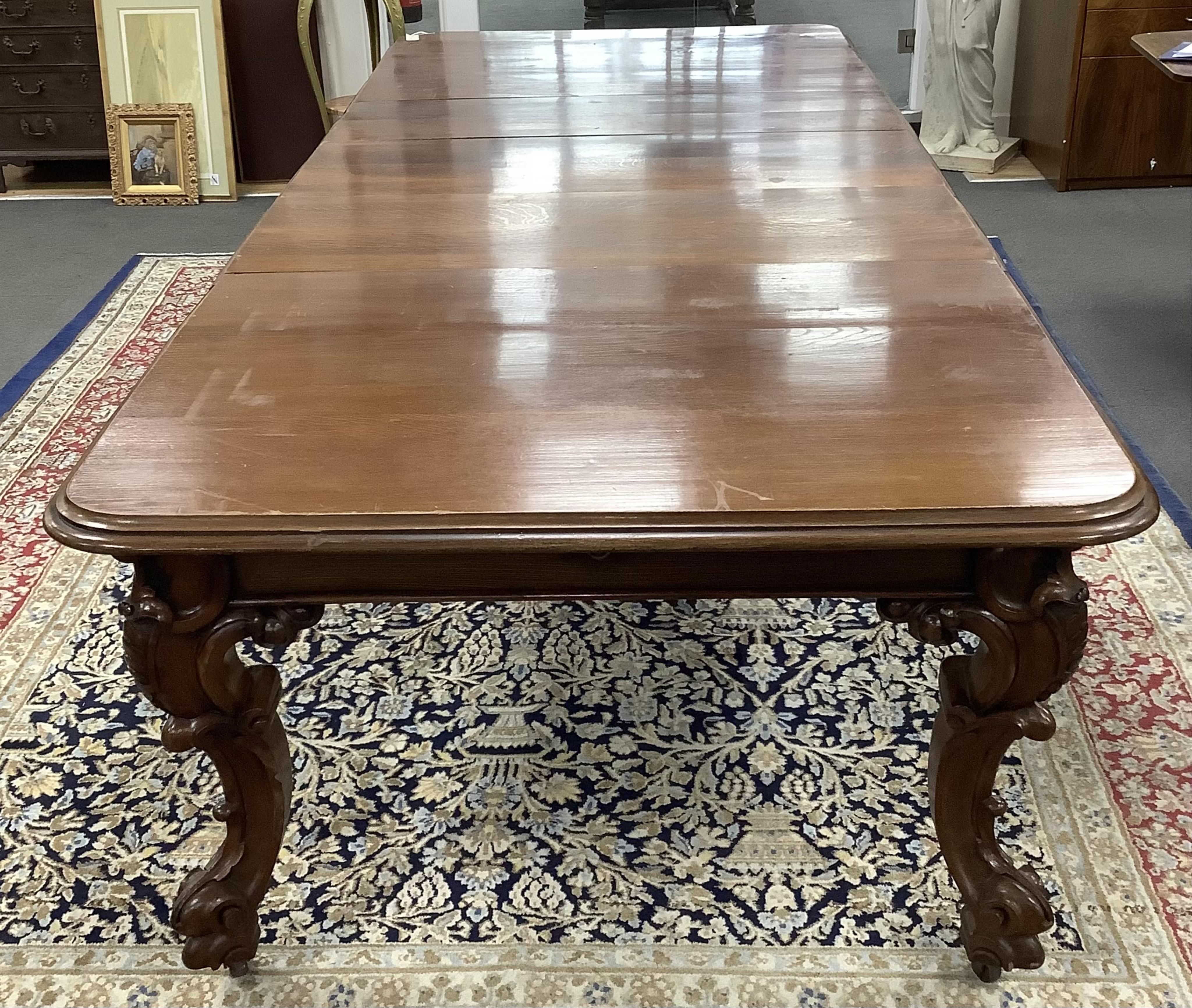 A Victorian oak extending dining table on carved cabriole legs, width 320cm extended, three spare leaves, depth 128cm, height 77cm. Condition - fair